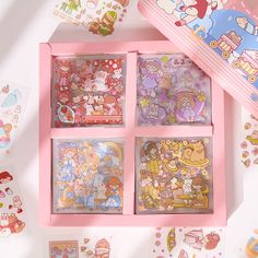 the pink box is filled with various stickers and paper crafts, including hello kitty