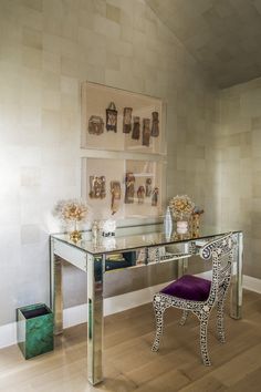 a desk with a purple chair and pictures on the wall behind it in a room