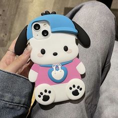 a person holding an iphone case with a dog on it's back and wearing a hat