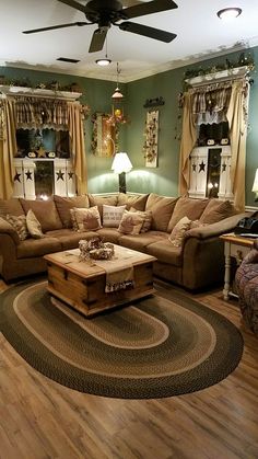 a living room filled with lots of furniture next to two lamps and a ceiling fan