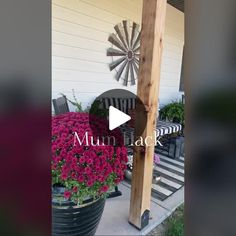 a wooden pole sitting in front of a flower garden