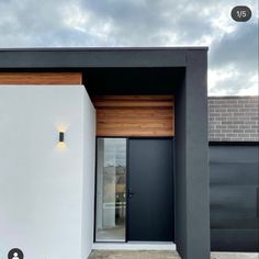 a modern house with black and white walls, wooden doors and windows on the outside