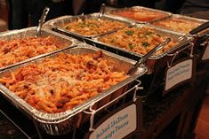 several trays of food on display at a buffet