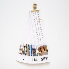 a calendar hanging on a clipboard with photos pinned to it's side and the words no sep written in black