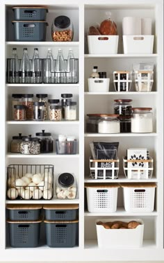 an organized pantry with white shelves and baskets