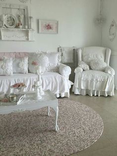 a living room filled with white furniture and lots of pillows on top of it's covers