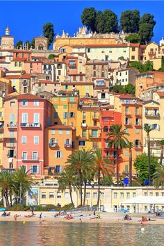 the beach is lined with colorful buildings and palm trees