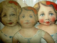 three old fashioned dolls sitting next to each other