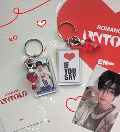 a couple of key chains sitting on top of a table next to a heart shaped card