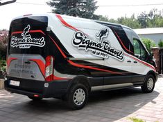 a black and white bus is parked on the street