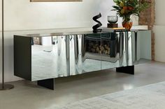 a modern sideboard with mirrored doors and a vase on top