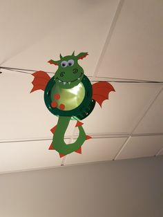 a green and red dragon hanging from the ceiling