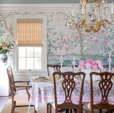 a dining room with floral wallpaper and chandelier