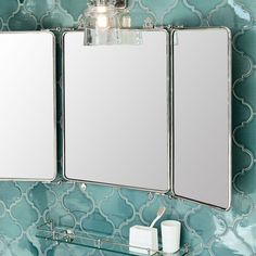 a bathroom mirror with two mirrors above it