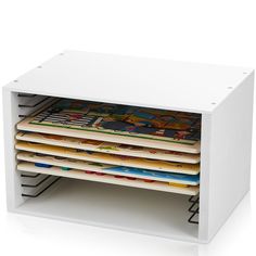 a stack of magazines sitting on top of a white shelf