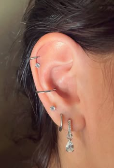 a close up of a person's ear with three different types of piercings