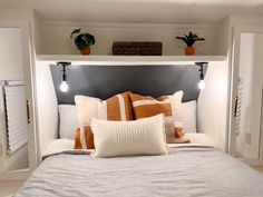 a bed with two plants on the headboard and one plant in the wall above it