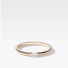 a gold ring with a baguettte in the middle and a diamond on top