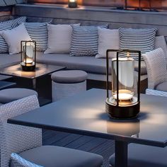 an outdoor seating area with lit candles on the tables