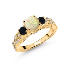 a gold ring with an opal and black stones