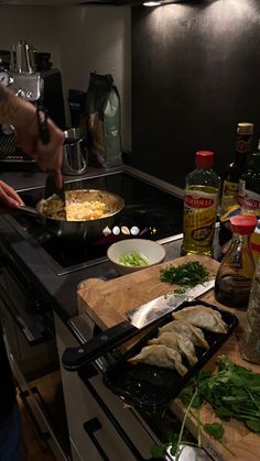 a person cooking food on top of a stove in a kitchen next to an oven