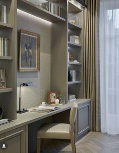 a home office with built in bookshelves, desk and chair next to a window