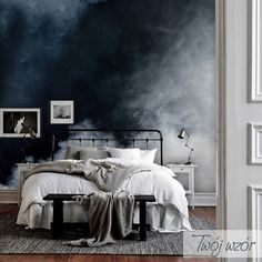 a bed sitting in a bedroom next to a wall with clouds painted on the walls