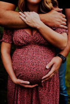 a pregnant woman is hugging her husband's belly