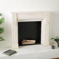 a white fireplace with books on the mantle