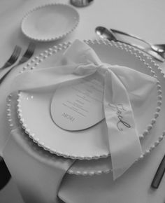 a table setting with white plates and silverware