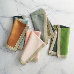 five folded napkins on a marble surface