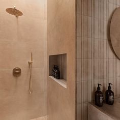 a bathroom with a shower, mirror and soap dispenser on the wall