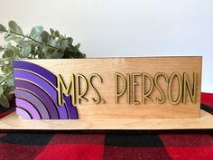 a wooden sign that says mrs pierson on it next to a potted plant