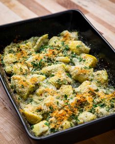 a casserole dish with broccoli, cheese and seasoning sprinkled on top