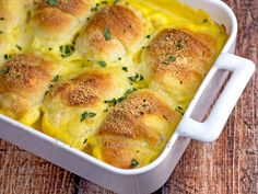 a casserole dish with cheese and bread in it on a wooden table top