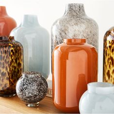 many different colored vases sitting on a shelf