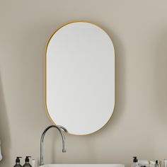 a bathroom sink sitting under a mirror next to a faucet mounted on a wall