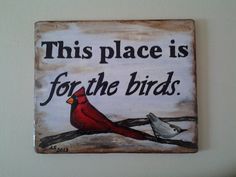 a wooden sign that says, this place is for the birds with two birds on it