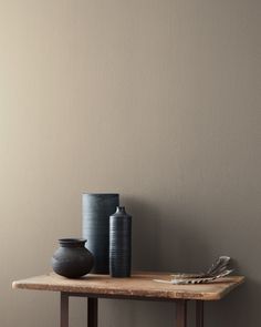 two vases are sitting on a wooden table