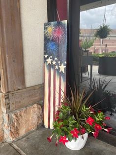 a potted planter with red, white and blue flowers in front of a door