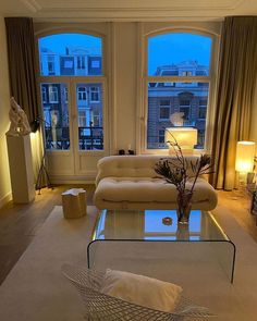 a living room filled with furniture and large windows