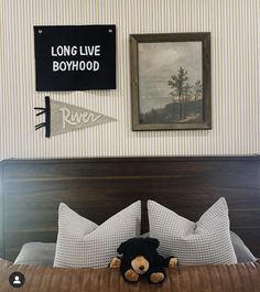 a teddy bear laying on top of a bed in a room with striped wallpaper