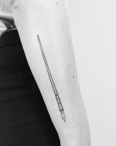 a black and white photo of a harry potter wand tattoo