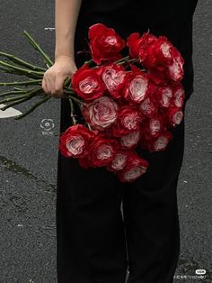 a person holding a bunch of red roses