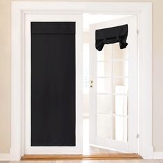 an open white door with black curtains on it