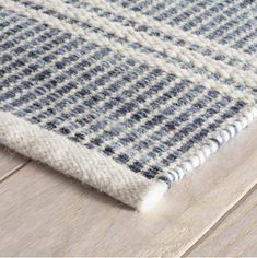 closeup of the blue and white rug on a wooden floor with wood planks