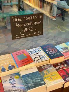 there are many books on display in the store window and one has a sign that says free coffee with any book from here