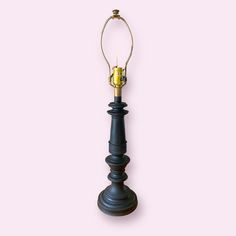 a black and gold lamp on a pink background