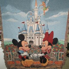 two mickey and minnie mouses in front of a castle