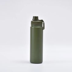 a green water bottle sitting on top of a white table